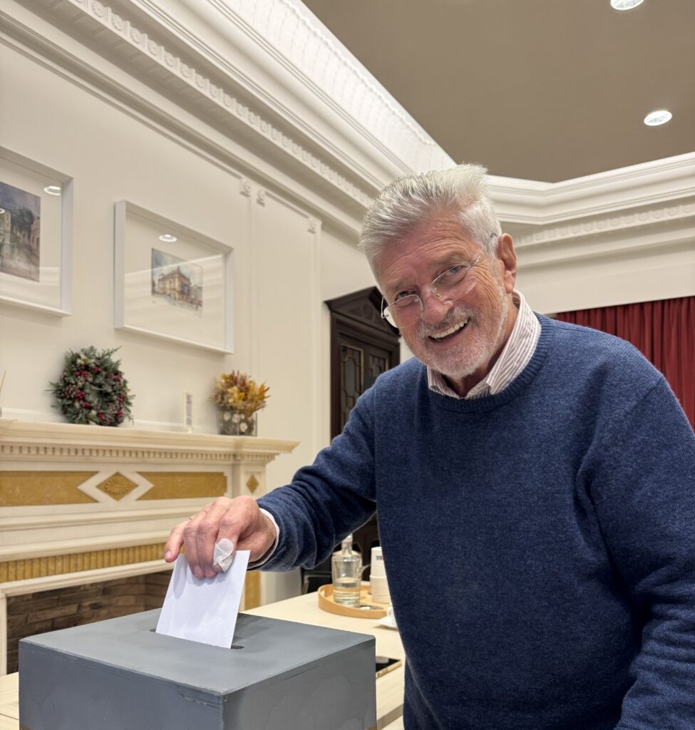 Ator Rui Mendes, sorridente, introduzindo o seu voto na urna